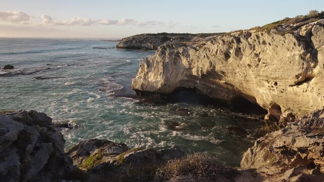 4k 60p footage of the rocky coastline near Waenhuiskrans Cave, Arniston. Towering cliffs meet ocean waves in Overberg seascape, Western Cape, South Africa. Ideal for nature and travel visuals.