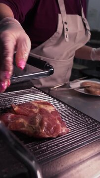 Cooking a steak. A professional chef prepares delicious meat on a hot grill