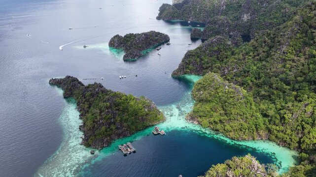 Cinematic aerial video of house boats in azure blue water lagoons with limestone cliffs at tropical islands of Coron in the Philippines 
