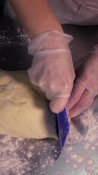 Cutting pie dough. A woman cuts pie dough in the kitchen