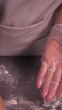 Kneading the pie dough. A woman rolls out the dough in the kitchen