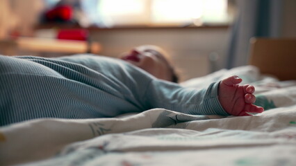 Obraz premium Close-up of baby foot while lying on bed, cozy moment of rest in softly lit bedroom, peaceful detail highlighting calmness and tenderness of early childhood