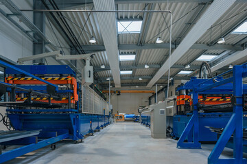 Fototapeta premium Automated production line inside a factory with industrial equipment and no people present in the interior space.