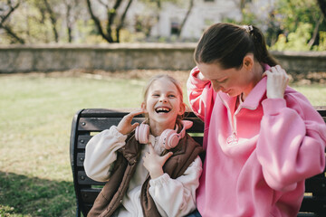 Happy mother and daughter relaxing in a park on sunny day.
