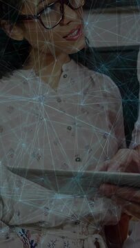 Vertical video: Woman holding tablet, man joining and pointing for shared review under web overlay