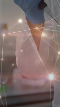 Vertical video: Gloved lab hand grasping pipet and pressing for sample transfer amid network lights