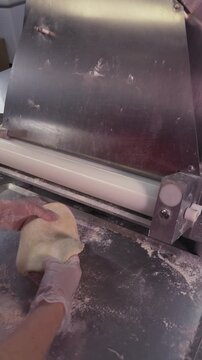 Roll out the dough mechanically. Vertical video about homemade pastries, cooking and confectionery.