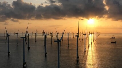 Offshore wind farm with turbines generating renewable energy at sunset