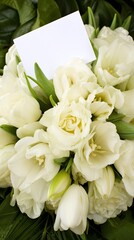 Fototapeta premium Blank greeting card placed on a bouquet of tulips with a background of leaves for special occasions like mothers day or valentines day