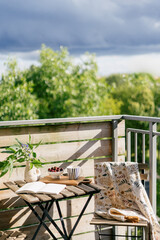 Fototapeta premium Cozy balcony setup for breakfast with nature view on a sunny day