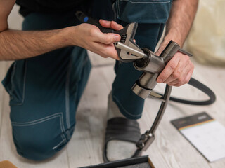 A plumber is replacing a faucet in the kitchen.
