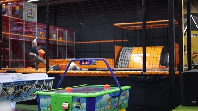 Kids playing on indoor playground in foam rubber pit in trampoline, active pastime in the amusement park. 