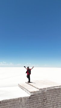 Man riding adventure motorcycle on Salar de Uyuni. Endless white landscape and rider on the vast Bolivian salt flats.