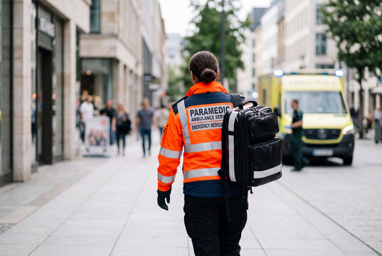 Paramedic in uniform walking toward ambulance in city street