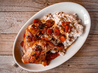 Roasted chicken drumsticks served with steamed rice and fresh vegetable salad on a plate