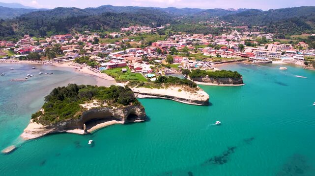 Canal d'Amour 4k drone orbit of unique sandstone rocks and Sidari town in Corfu. Aerial 180 degree panoramic view of romantic beach and turquoise sea in Greece. Cinematic coastal travel scenery