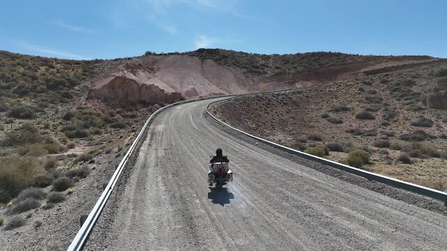 Man riding adventure motorcycle on the iconic Route 40 (Ruta 40) in Santa Cruz. Endless highway through the Patagonian steppe.