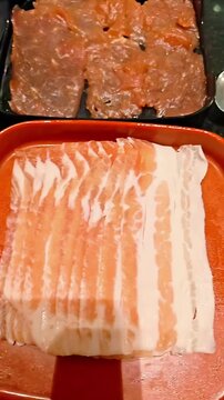 Sliced BBQ raw beef cut variety on plastic trays, Korean Japanese Barbeque Marbled Meat, Shabu Hot Pot, Asian Cuisine Dining Gourmet Butcher Preparation, Panning Shot