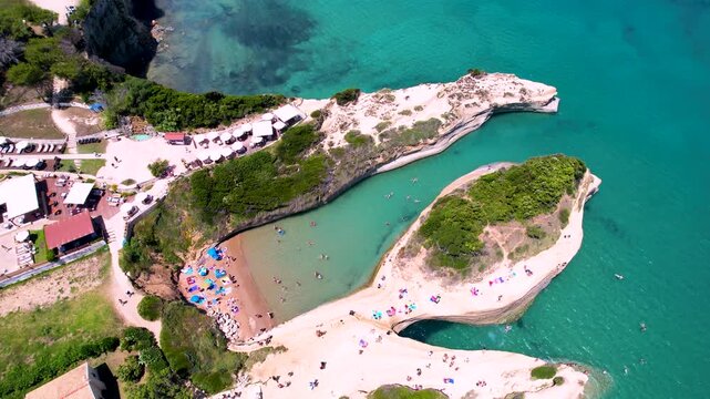 Canal d'Amour 4k drone reveal of unique rock formations and beach in Sidari Corfu. Aerial tilt up view of famous romantic bay and turquoise sea in Greece. Scenic coastal landscape travel scenery
