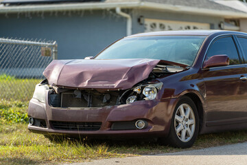 Damaged vehicle involved in traffic accident parked along neighborhood roadside near houses, highlighting safety and traffic awareness.