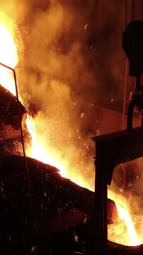 Liquid metal in the foundry, melting iron in furnace, steel mill. Smelting is a process of applying heat to ore in order to extract a base metal