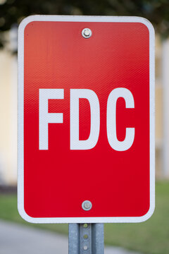 Detailed vertical image of a reflective red FDC marker mounted on a galvanized post, isolated against a softly blurred exterior setting