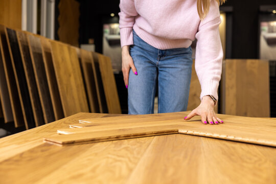 woman choosing parquet design in flooring shop