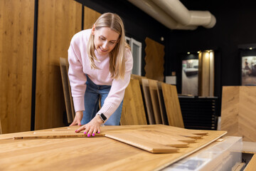 woman choosing parquet floor design to buy in flooring shop