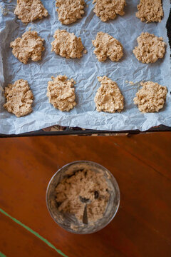Baking tray and mixing bowl with uncooked raw oatmeal cookie dough, rural lifestyle, cosy home baking