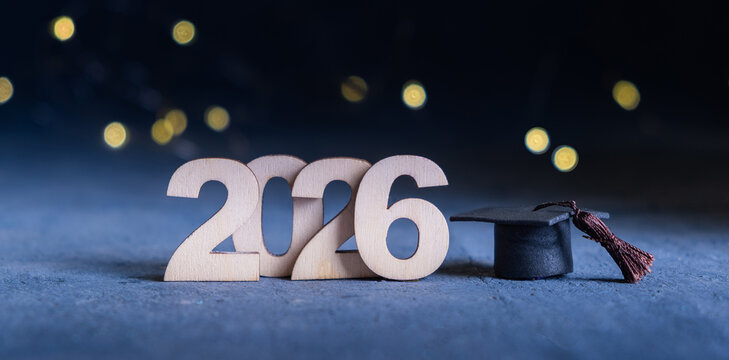 Class of 2026 banner. Number 2026 with graduate hat on dark blue background with bokeh