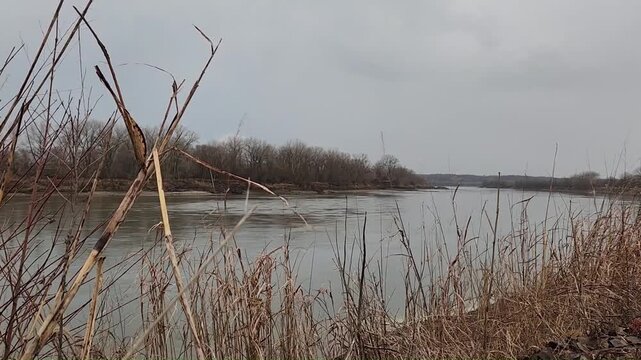 Branching lightning sequence over river with buildup and multiple flashes during daytime thunderstorm