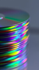 Fototapeta premium Stack of colorful optical discs reflecting rainbow light representing digital storage and media technology.
