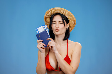 Fototapeta premium Young tourist woman holding passport and flight tickets on a clean isolated background. International tourism and travel concept. 