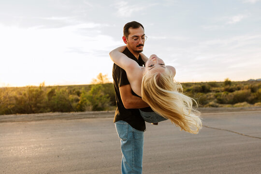 Couple in a desert road looking back