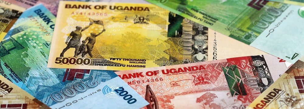 Ugandan shilling paper banknotes pile on table. Uganda UGX currency money bills in big amount. Concept of economics, taxation and banking in Uganda