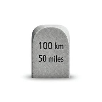 Isolated grey stone milestone marker clearly displaying 100 kilometers and 50 miles, symbolizing travel progress, journey achievements, and distance measurement
