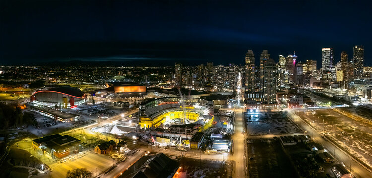 Calgary, Alberta, Canada. March 13, 2026. High-angle night panorama of the Calgary skyline featuring the Scotiabank Saddledome and BMO Centre.