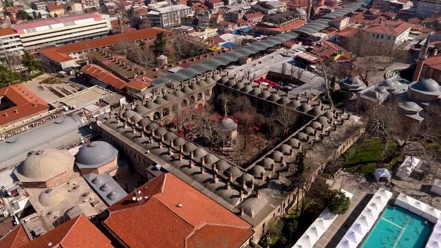 Aerial drone view of the historic Koza Han courtyard and Ottoman bazaar complex in Bursa, Turkey.