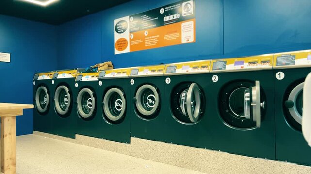 Self Service Laundromat Interior With Row Of Washing Machines