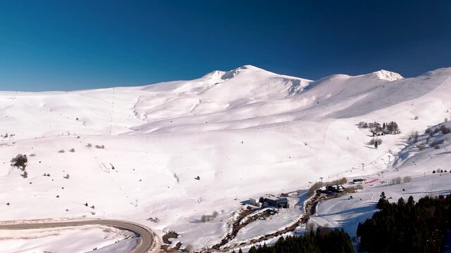 Wide aerial view of snowy mountains and ski slopes in Turkey.
