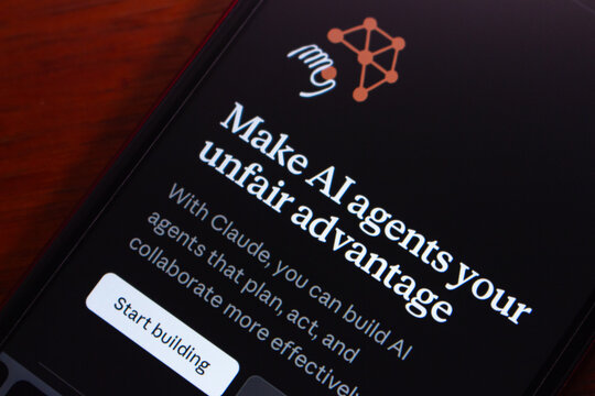 Quito, ECUADOR - Mar 9 2026 : Close-up of a smartphone screen showing the Claude AI agents webpage on a wooden surface.