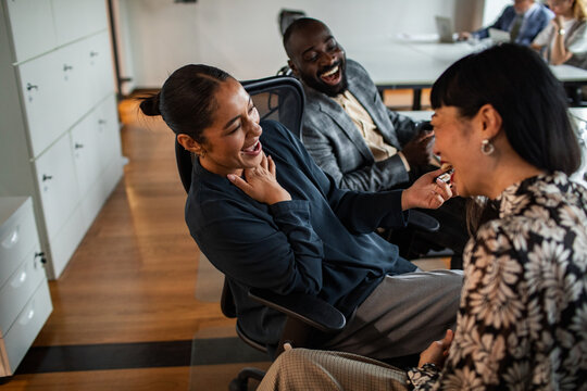 Diverse coworkers laughing together in modern office