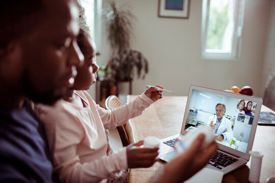 Father and child consulting pediatrician via telemedicine at home