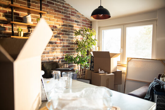New homeowners unpacking moving boxes in bright loft living room