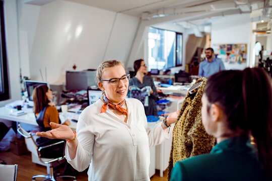 Designers reviewing garment samples in modern fashion studio