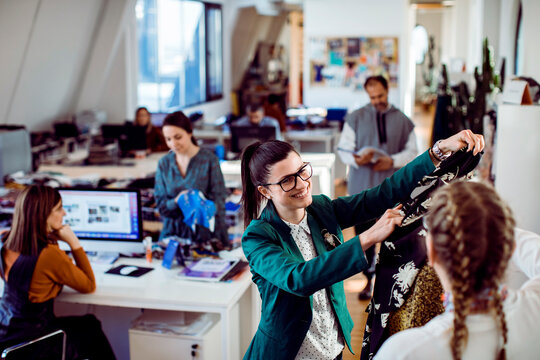 Fashion designers collaborating on garment in modern studio