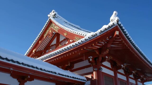薄雪が縁取る朱塗りの社殿屋根