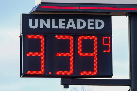 Unleaded gasoline price sign with red LED digital numbers displaying 3.39 on a roadside fuel station sign.
