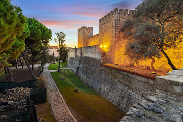 The illuminated Castelo de São Jorge, or St. George's Castle, a medieval hilltop fortress in the historic Alfama district overlooking the city of Lisbon, Portugal, at sunset. © Kirk Fisher
