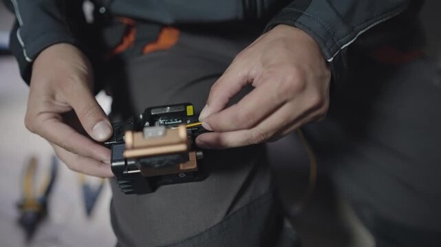 Technician performing precise optical fiber splicing for network cable connectivity